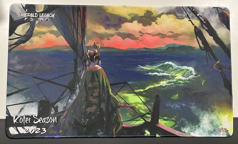 Photo of the optional participation playmat, which shows the Empress on her boat, looking at the horizon where Sanctuary appears.