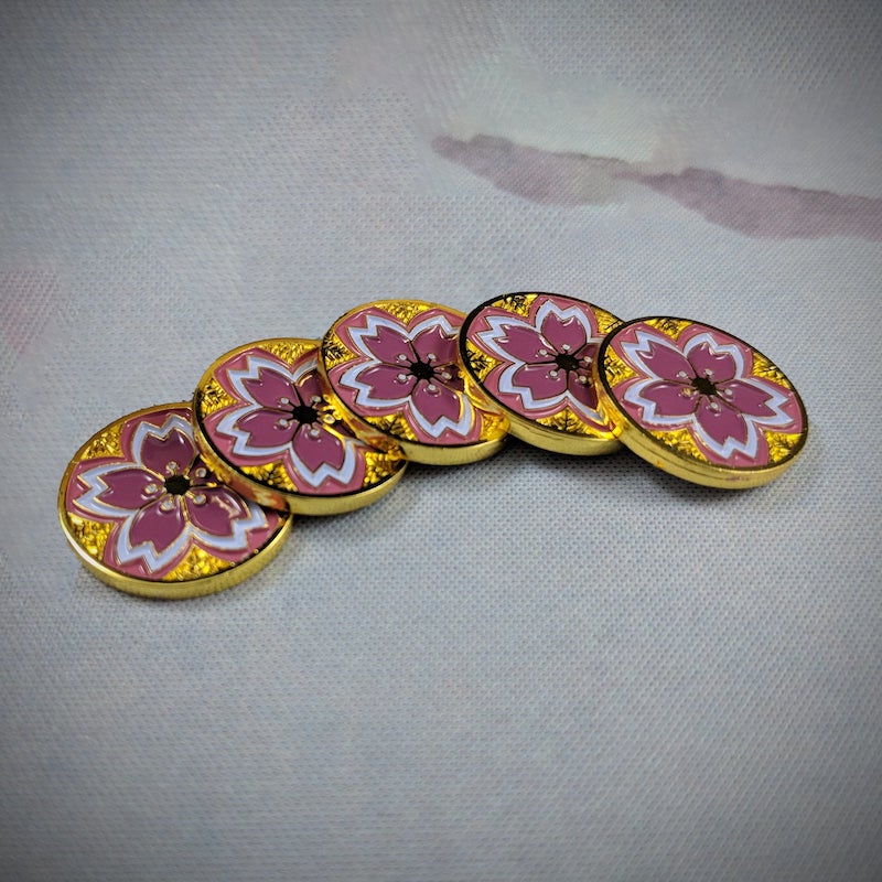 a set of five tokens, fanned out but overlapping each other, showing the fate side of Luxury Playstyle's Summer Gold sakura tokens. 