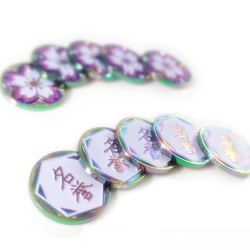 two sets of five tokens each, stacked on each other, showing the fate side and the honour side of Luxury Playstyle's Iridescent sakura tokens. 